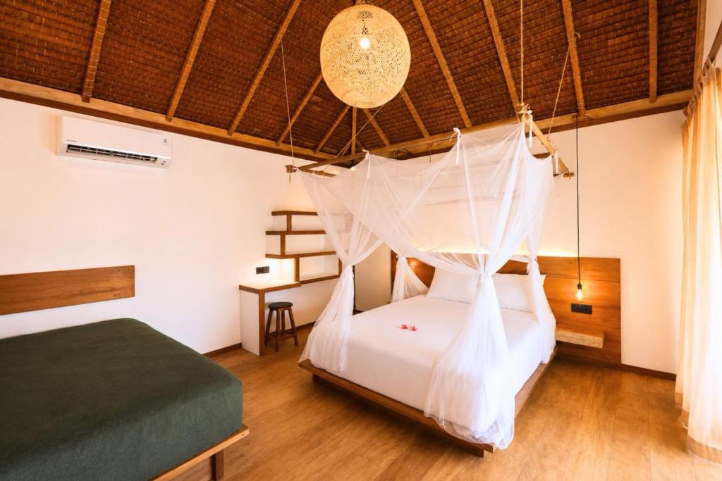 a bedroom with a bed with a mosquito net at Akar Mentawai in Simpatdegat