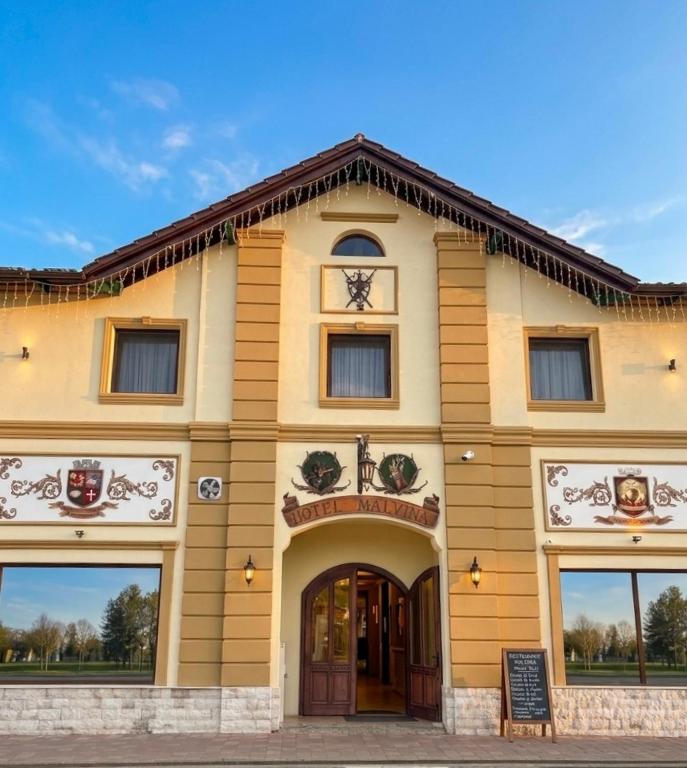 a building with a sign in front of it at Hotel Malvina in Sînnicolau Mare