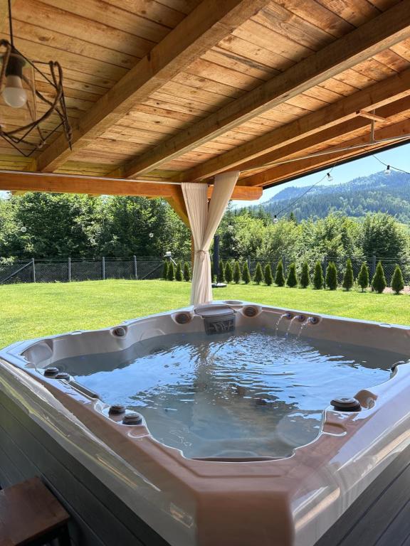 a hot tub under a wooden roof at Villa Ema in Pale