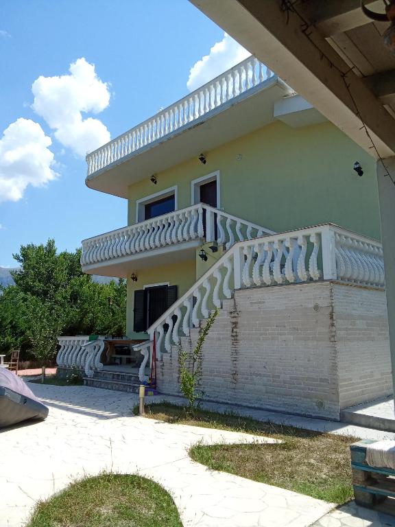 a house with a staircase in front of it at Vila Blue River in Orikum