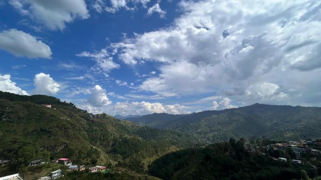 a view of a valley with mountains and clouds at Hotel Almora Palace in Almora