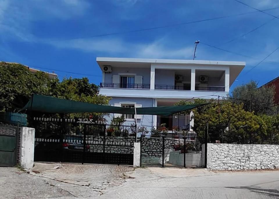 a white house with a fence in front of it at Meto Rooms in Sarandë