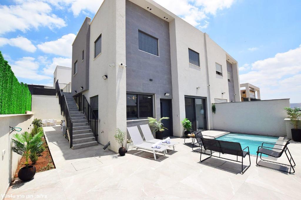 a house with a swimming pool in front of it at וילה מושלמת עם בריכה מפנקת וממ"ד בשכונת טבריה המושבה בעיר טבריה in Tiberias