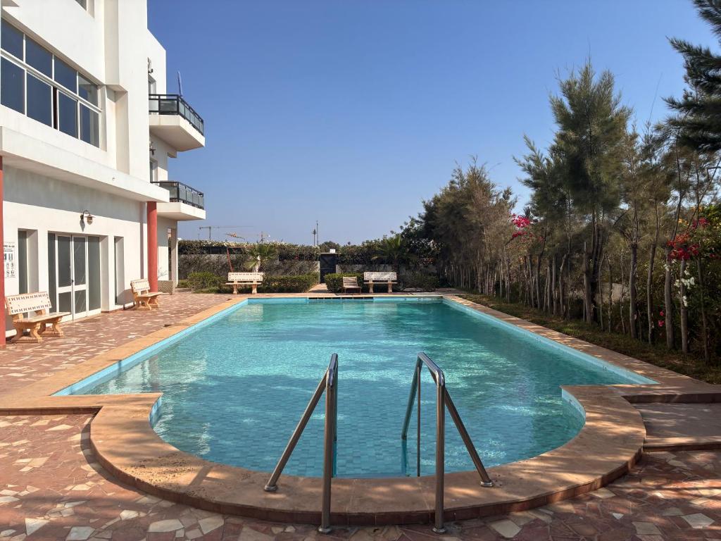 a swimming pool in front of a building at Agadir 1 plage piscine terrasse in Agadir