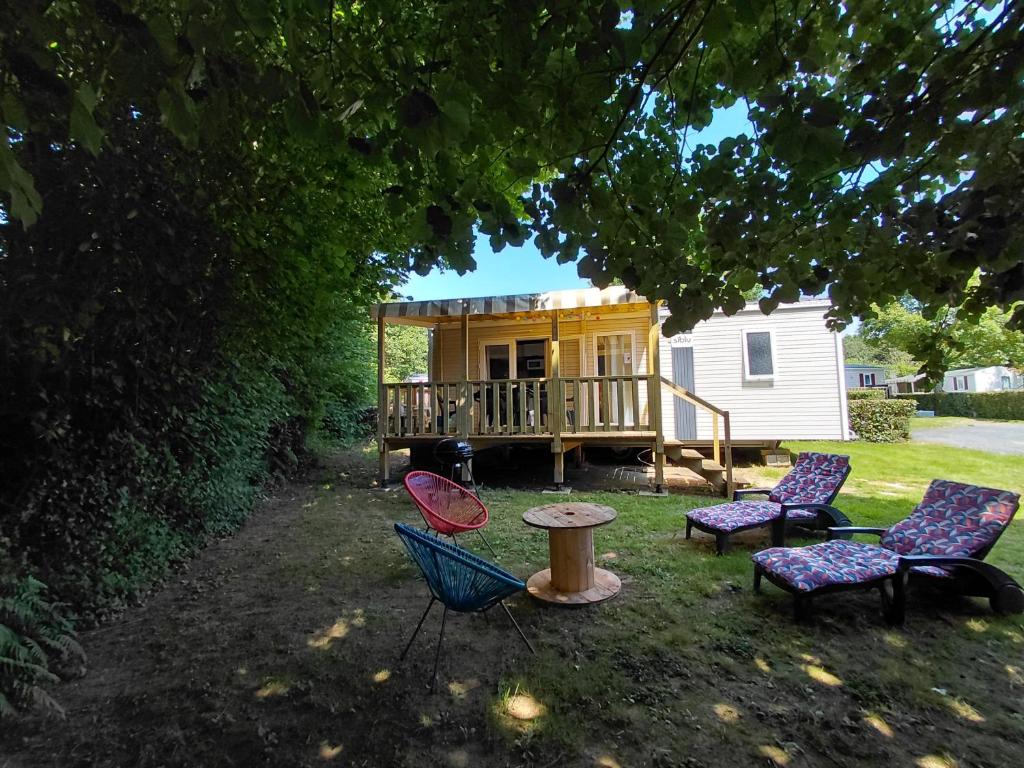 a group of chairs and a table in front of a cabin at Mobil home Salsa in Litteau