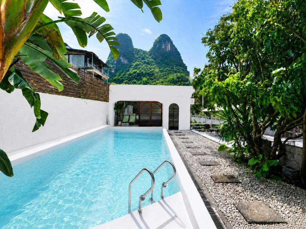 a pool at a resort with a mountain in the background at Yulong River Scenic Area,Floor-to-ceiling Windows for viewing,Swimming Pool & Coffee & Butler Service,10 minutes by car from West Street in Yangshuo