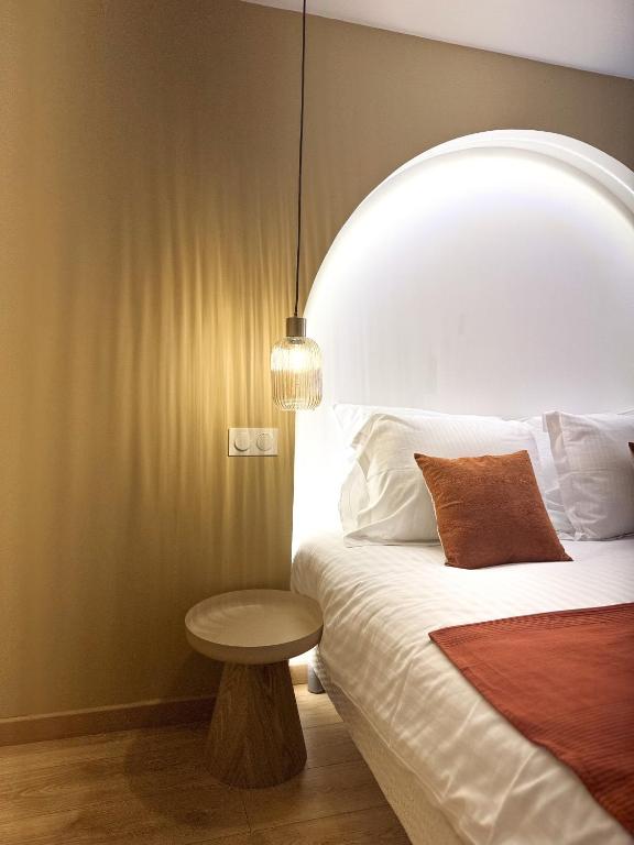 a bedroom with a bed with a table next to it at Les arches in Riom