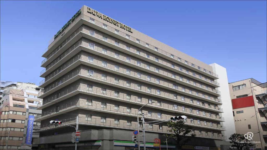 a tall building with a sign on top of it at Daiwa Roynet Hotel Kobe Sannomiya in Kobe