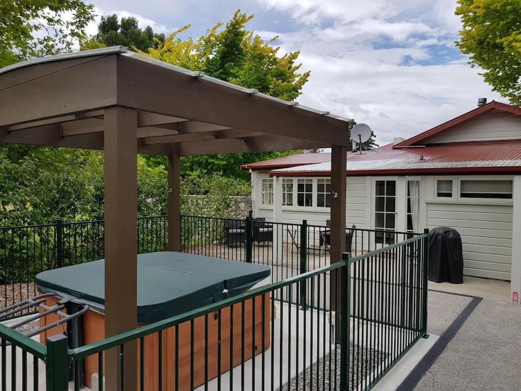 a picnic table under an umbrella on a fence at Rose Cottage - Tranquil retreat in Tinui