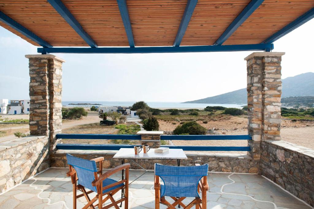 a patio with a table and chairs and a view of the ocean at Dimitris Rooms in Manganari