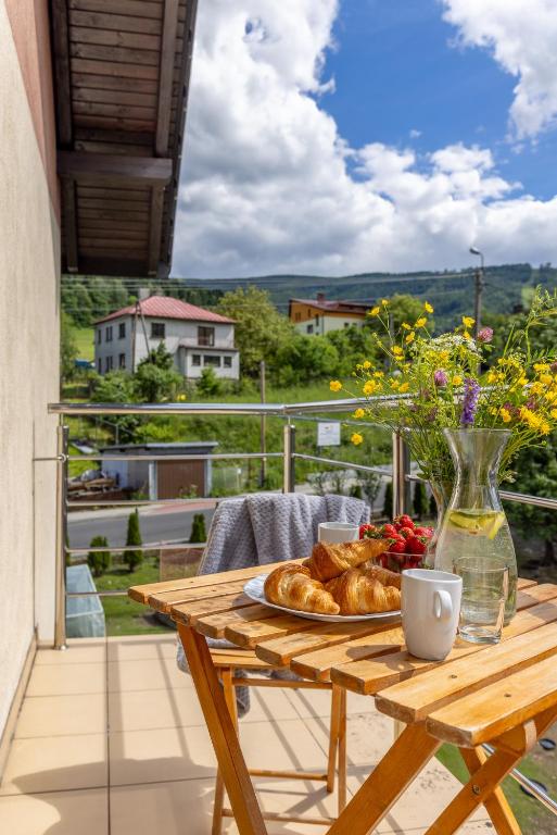 a table with a plate of bread and a vase of flowers at Willa Beskidek PLUS in Szczyrk