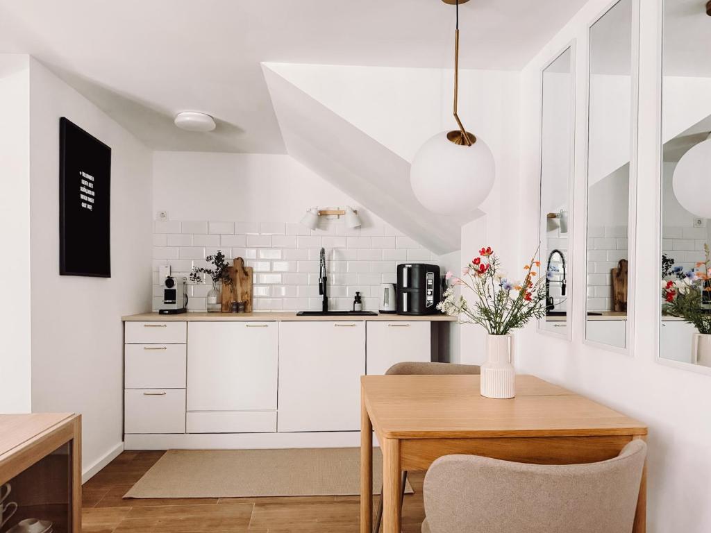 a kitchen with white cabinets and a wooden table at Studio Bachgeflüster in Schattendorf