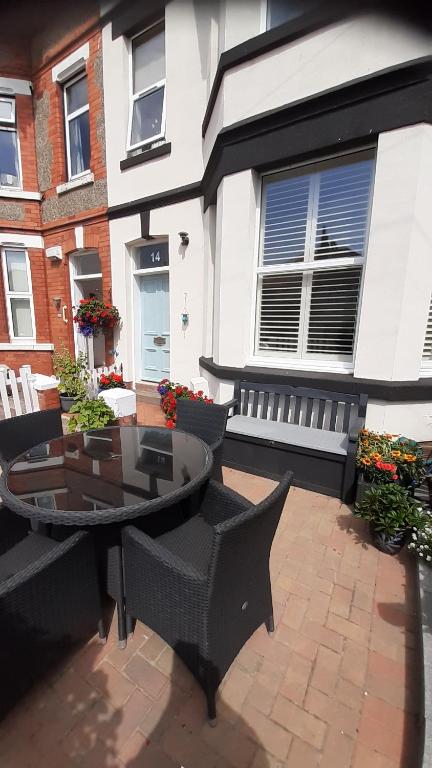 a patio with a table and chairs and a building at Victorian seaside apartment in West Kirby