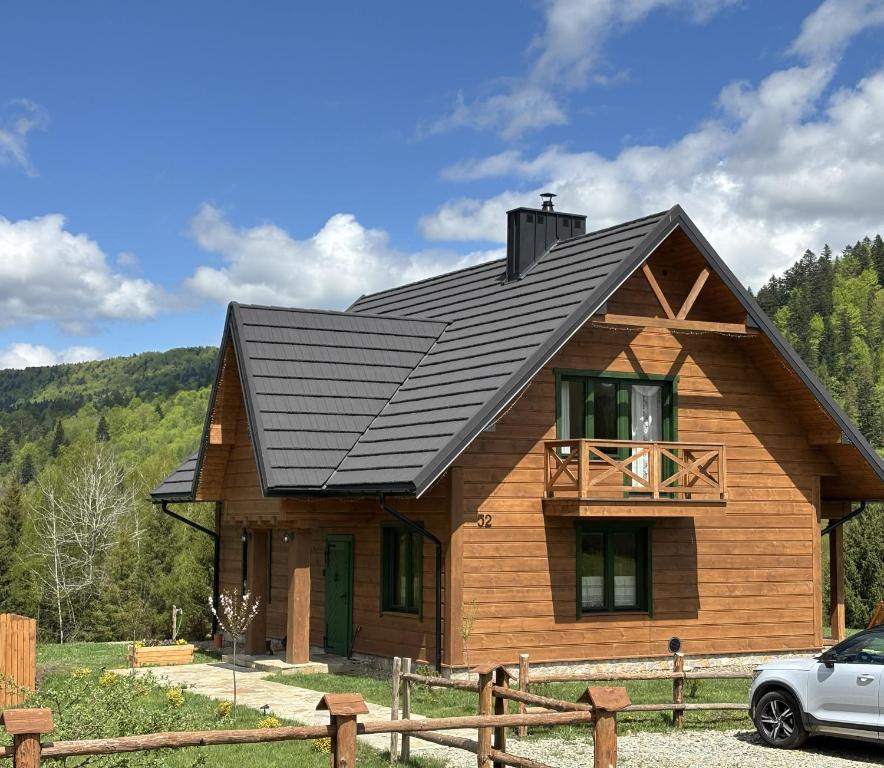 a wooden house with a black roof at Chata pod Jelenim Skokiem in Cisna