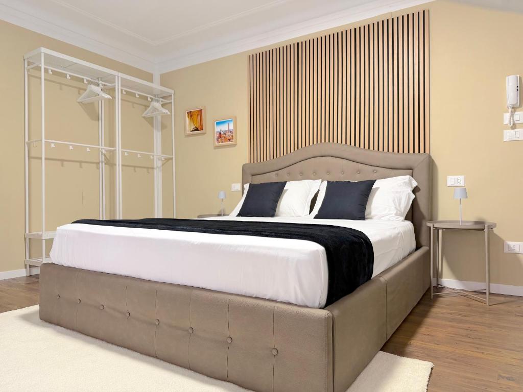 a bedroom with a large bed with white and blue pillows at Ugo Jacuzzi Apartment in Bologna