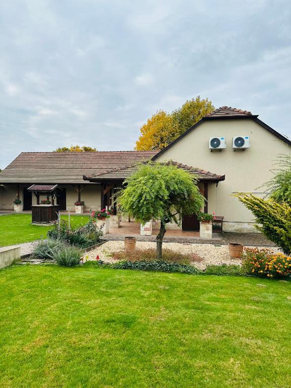 a house with a green yard in front of it at Furmint Vendégház in Tállya