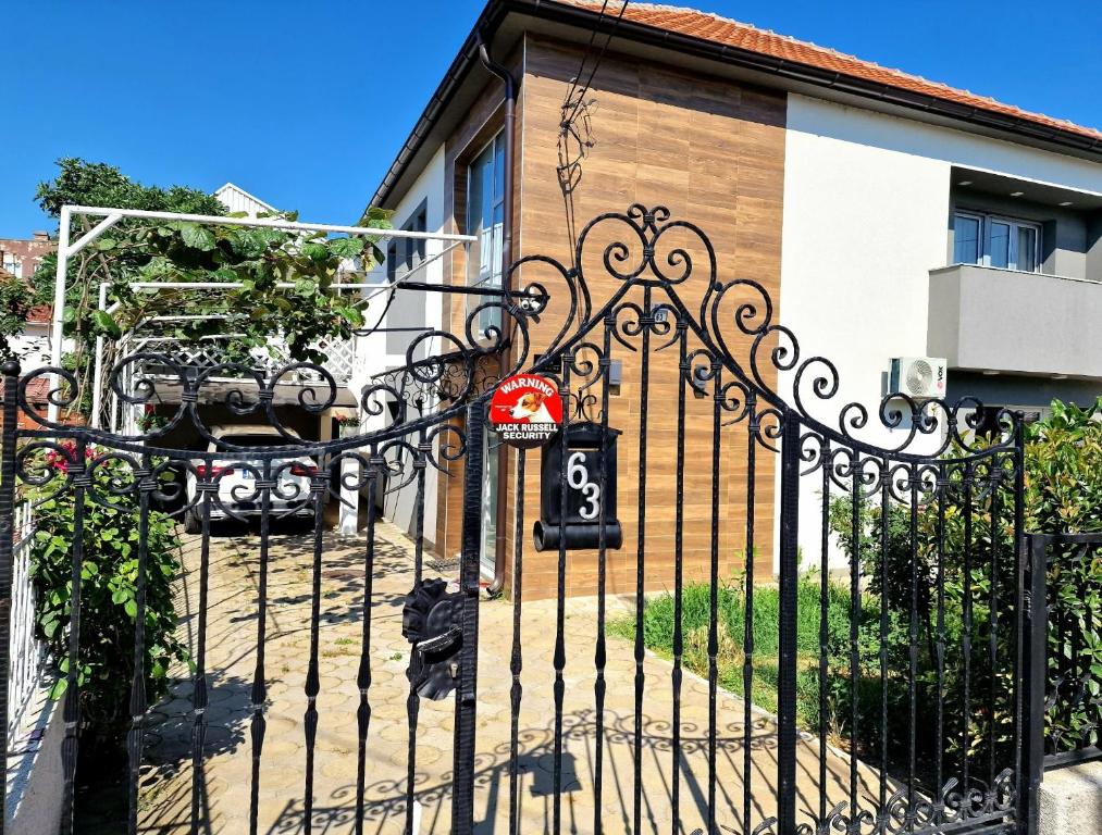 a black gate with a sign on it in front of a house at Apartman Vesna in Leskovac