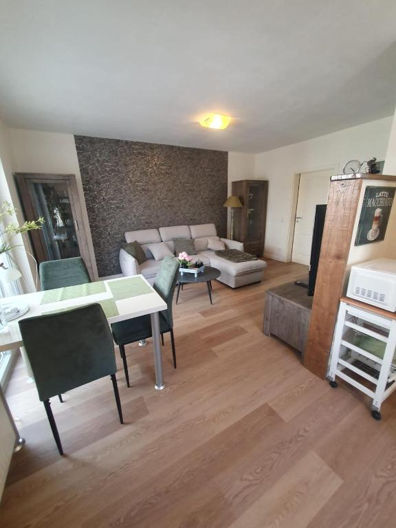 a living room with a couch and a table and chairs at Ferienwohnung Dreiländereck Gronau in Spechtholzhock