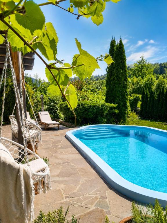 a swimming pool in a yard with a swing at Landhaus Sisi - River&Pool in Bad Ischl
