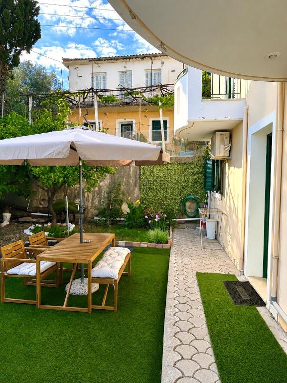 a patio with a wooden table and an umbrella at Nefeli’s guest house in Nydri