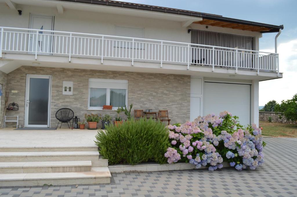 a house with a balcony and flowers in front of it at Marina in Čapljina
