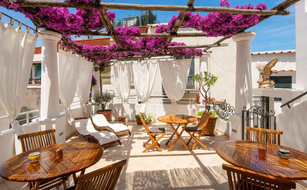 a patio with tables and chairs and purple flowers at alle Stelle b&b by FM, Capri Stays in Anacapri