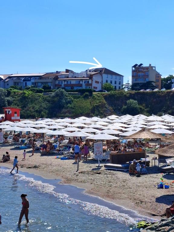 a group of people on a beach with umbrellas at Apartament DelyMar in Agigea