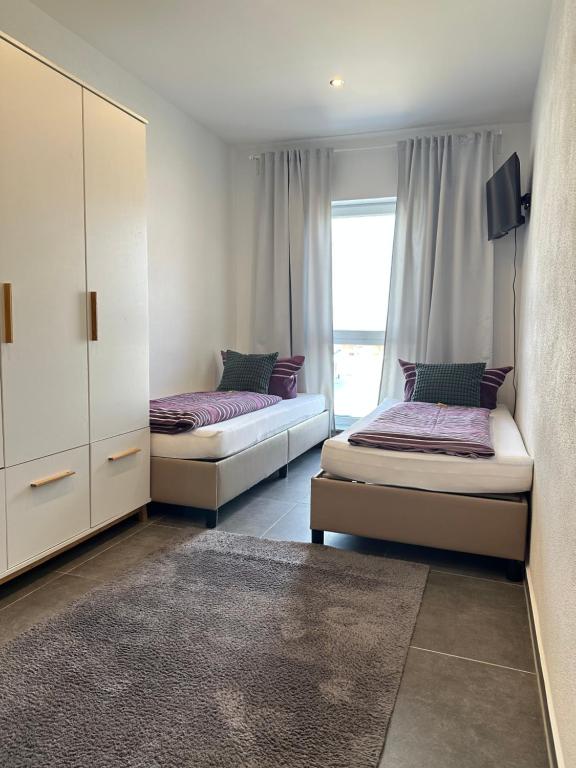 a bedroom with two beds and a window at Gemütliches Doppelzimmer Gemeinschaftsbad in Dingolfing
