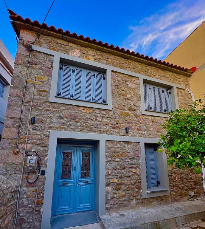 a stone house with blue doors and windows at The Prοfessοrs House - Myrina 1922 in Myrina