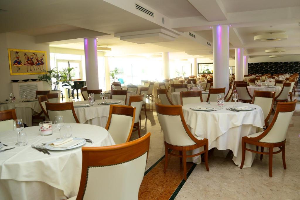 a dining room with white tables and chairs at Hotel Terme Marine Leopoldo II TERME & SPA in Marina di Grosseto