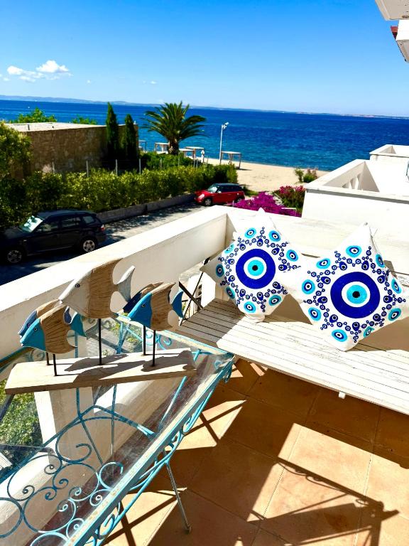 a bench with blue and white pillows on a balcony at Hara's House 1 in Gerakini