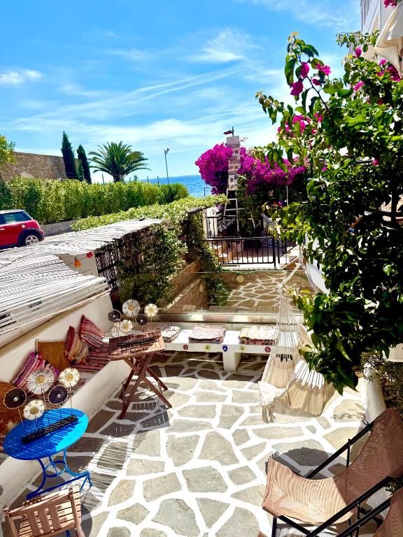 a patio with chairs and tables and flowers at Hara's House 2 in Gerakini