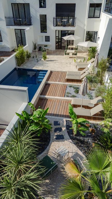 a courtyard with chairs and a pool in a building at L'ODE A PIERRE - Chambres d'hôtes in Dax