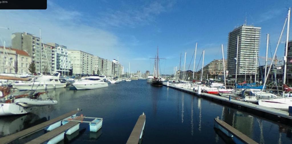 a group of boats docked in a marina with buildings at B&B Mercator in Ostend