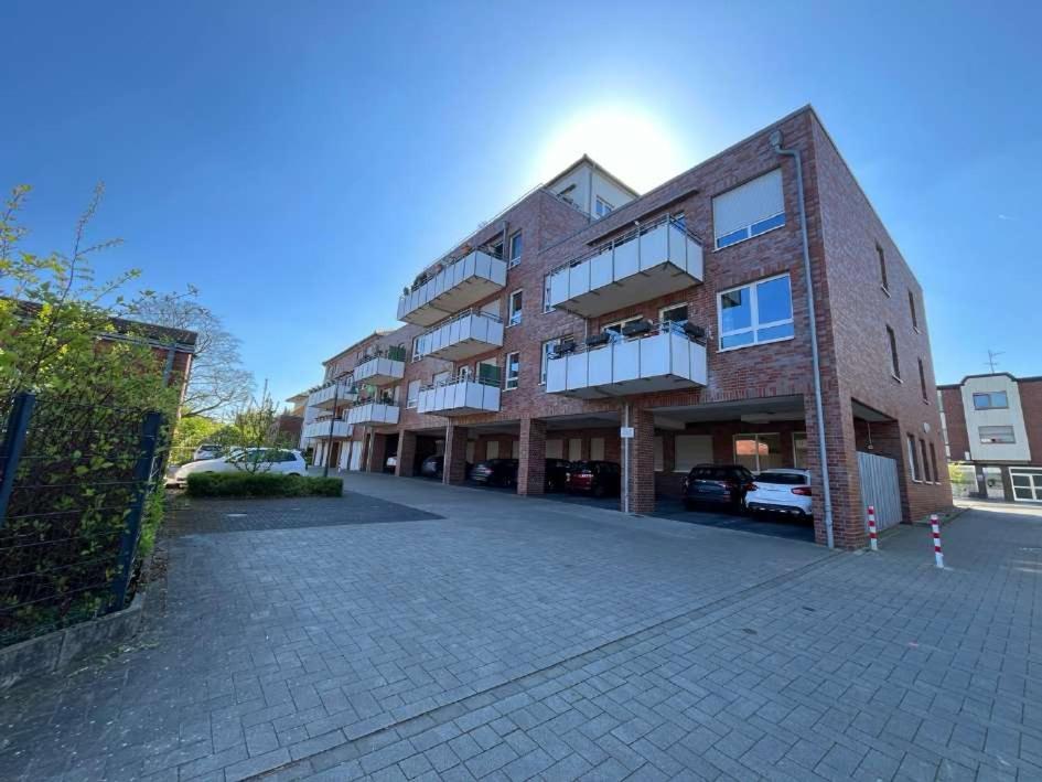 a brick building with a parking lot in front of it at Allegra am Niederrhein in Neukirchen-Vluyn