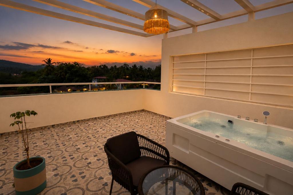 a bathroom with a jacuzzi tub on a balcony at Hotel H F at Assagao North Goa in Assagao