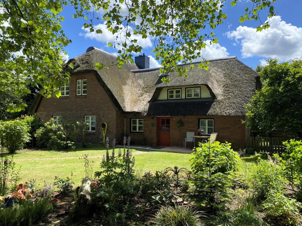 a large brick house with a thatched roof at Charmante Ferienwohnung unter Reet in Windbergen
