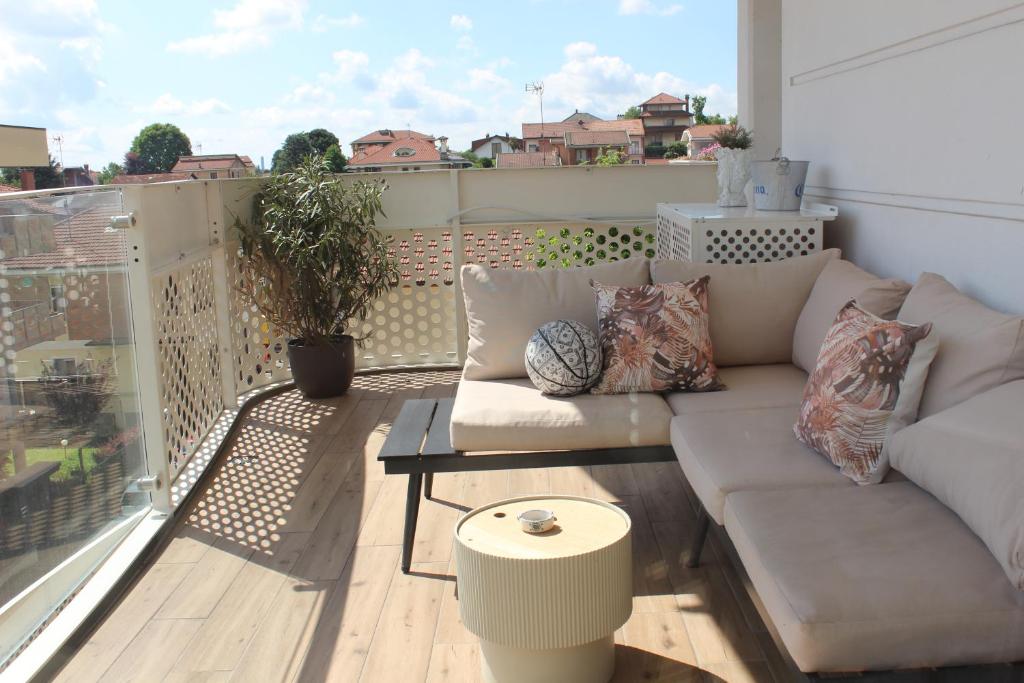 a living room with a couch on a balcony at GM House - Appartamento luminoso con grande terrazza vicino Torino in Collegno