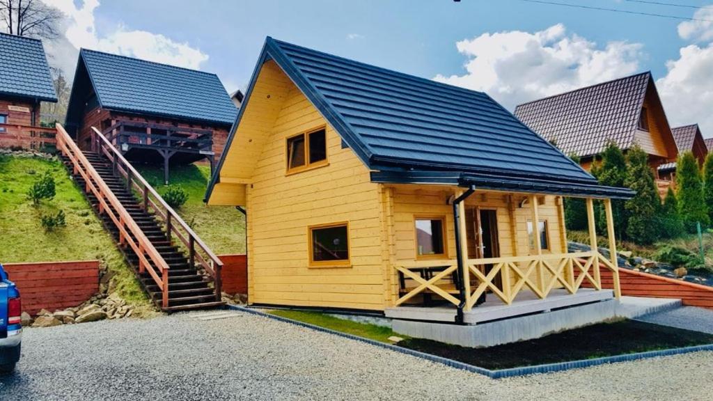 a small wooden house with a blue roof at Domek u Pusi z jacuzzi in Solina