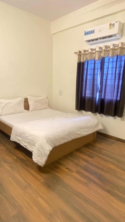 a bedroom with a bed with a blue curtain at Rajyog Resort in Dhule