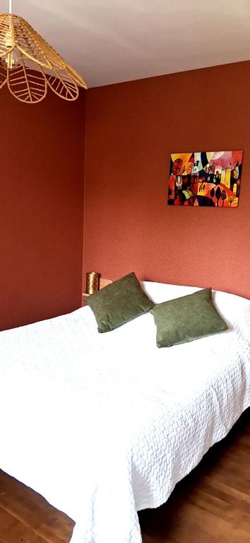 a bedroom with two white beds and a red wall at Logement entier RDC quartier historique Parthenay in Parthenay