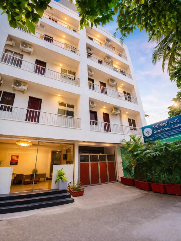 a large white building with a large courtyard at Guest House Suites in Bangalore