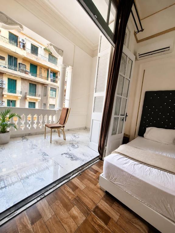 a bedroom with a bed and a chair on a balcony at An ancient pal ace in Cairo