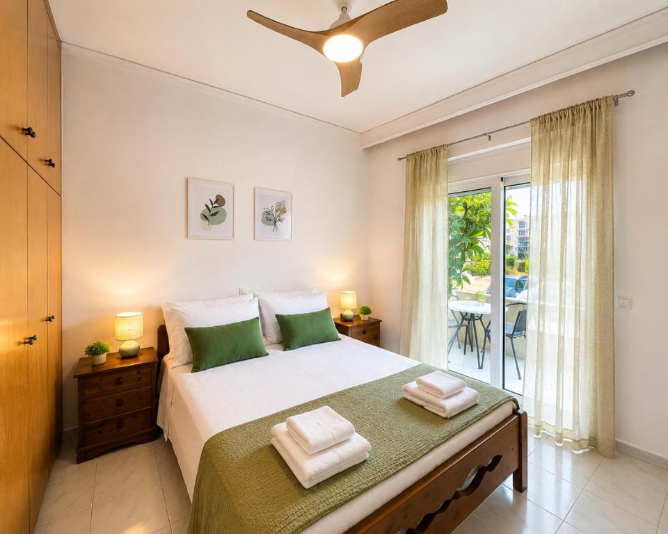 a bedroom with a large bed and a balcony at Linda's Apartment in Ialysos