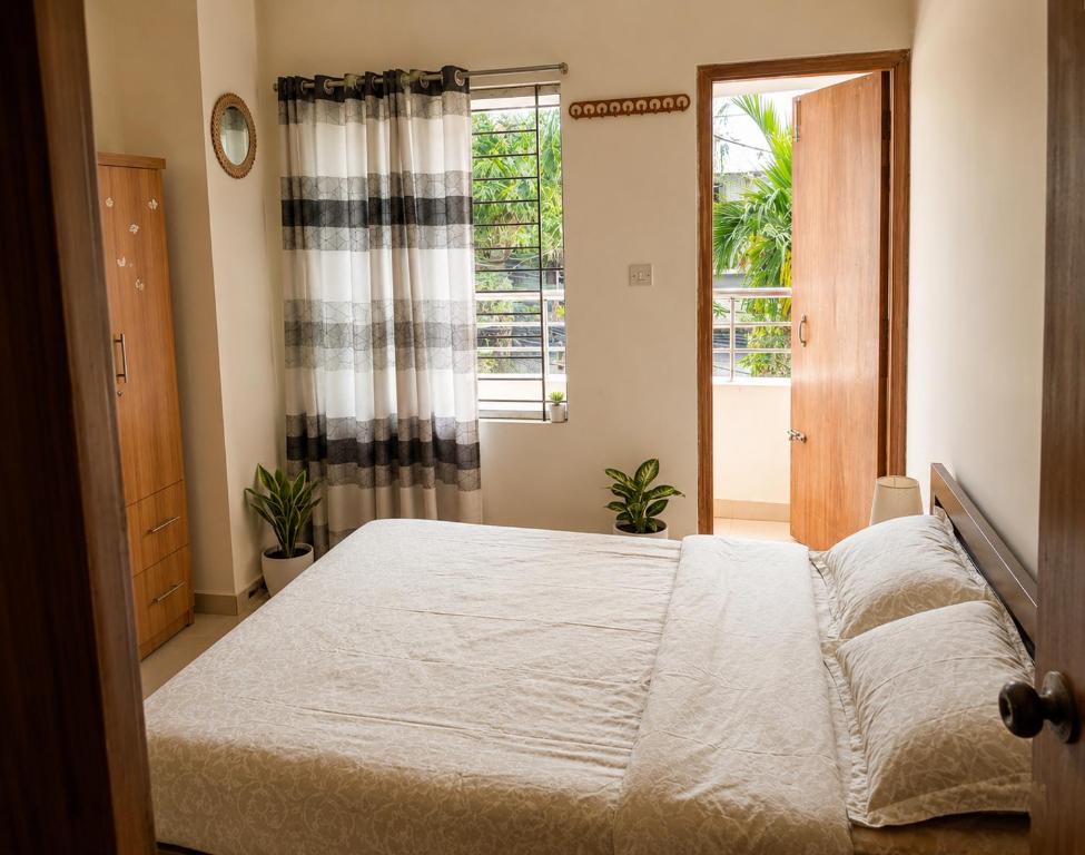 a bedroom with a large bed and a window at One Private Room Near Dhaka Airport in Dhaka