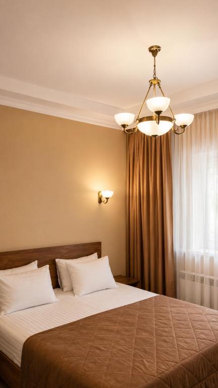 a bedroom with a large bed with a chandelier at Сонячна Соната in Polyana