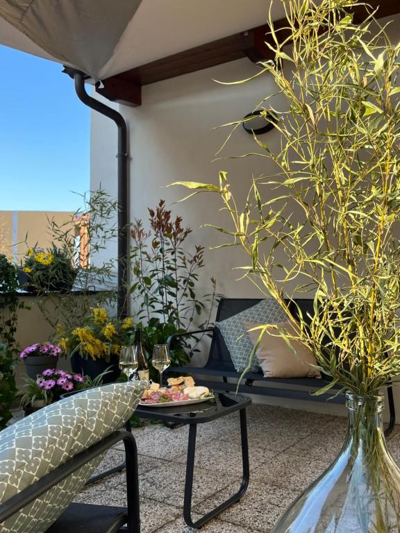 a small balcony with a table and some plants at Alba in Fiore in Alba