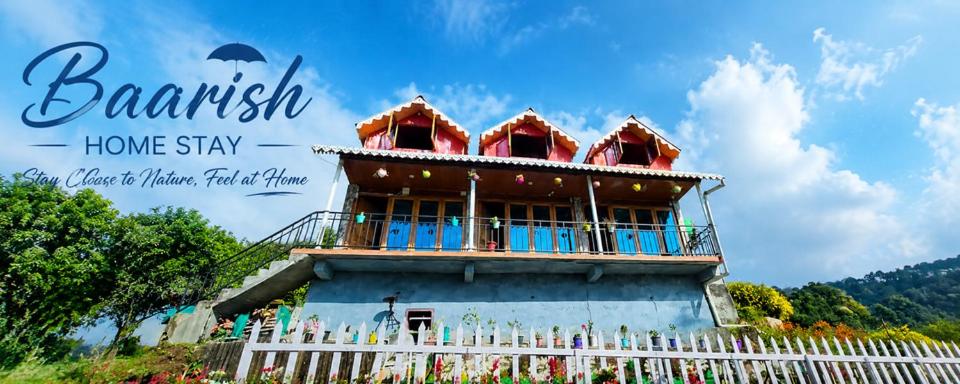 a house with a balcony on top of it at Baarish Home Stay in Kalimpong