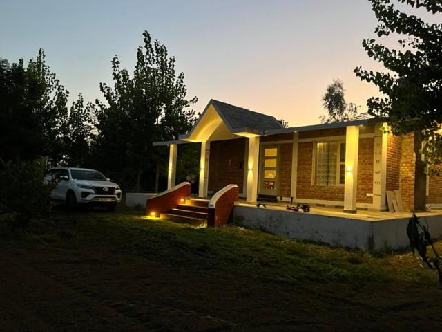 a small house with a car parked in front of it at RajKamal's Farm in Borās