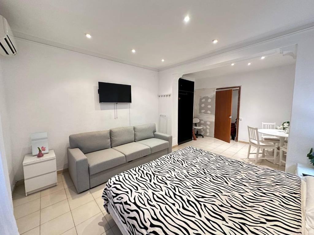a living room with a bed and a couch at Consell Habitaciones in Barcelona
